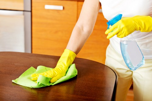 Cleaner sanitising desks in a Fulham office